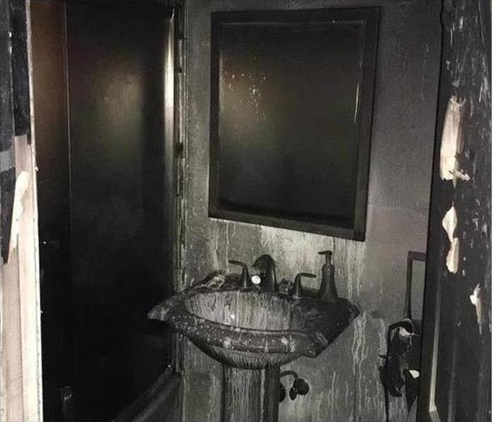 Soot covering restroom mirror and cabinets 